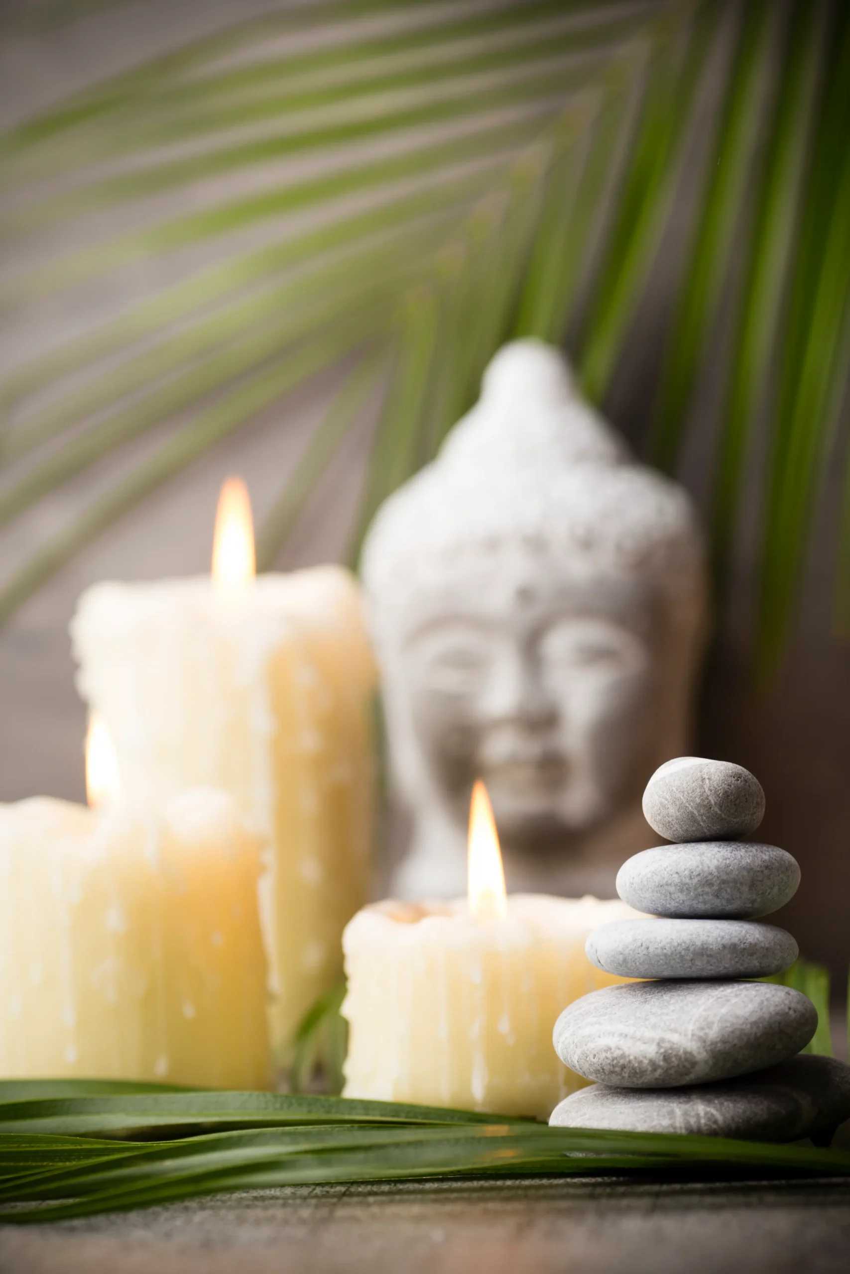 Velas, piedras y figura de Buda de fondo